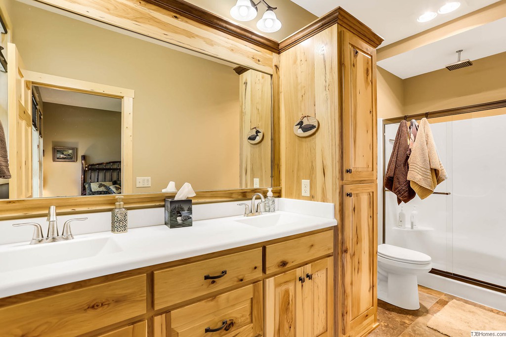 Large master bath with rustic look custom cabinets and rain style showerhead